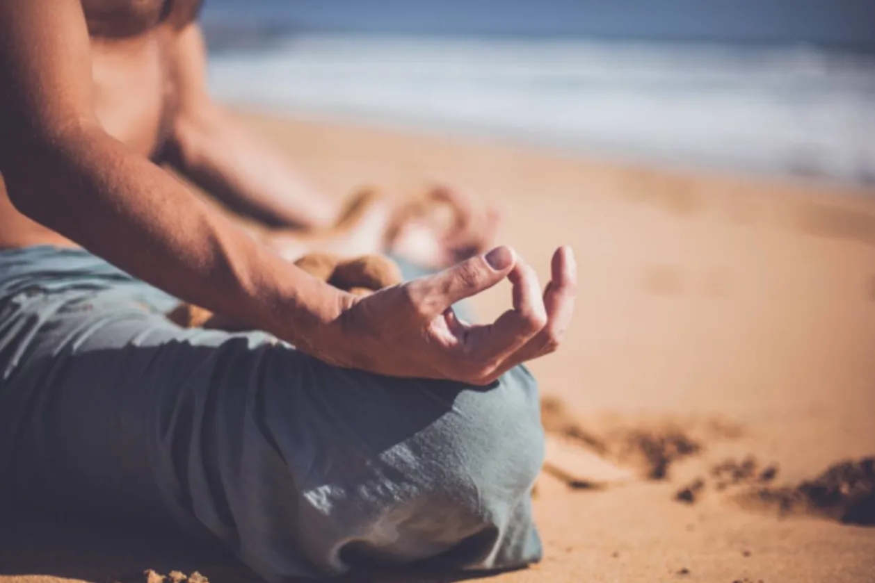 man on beach meditating
